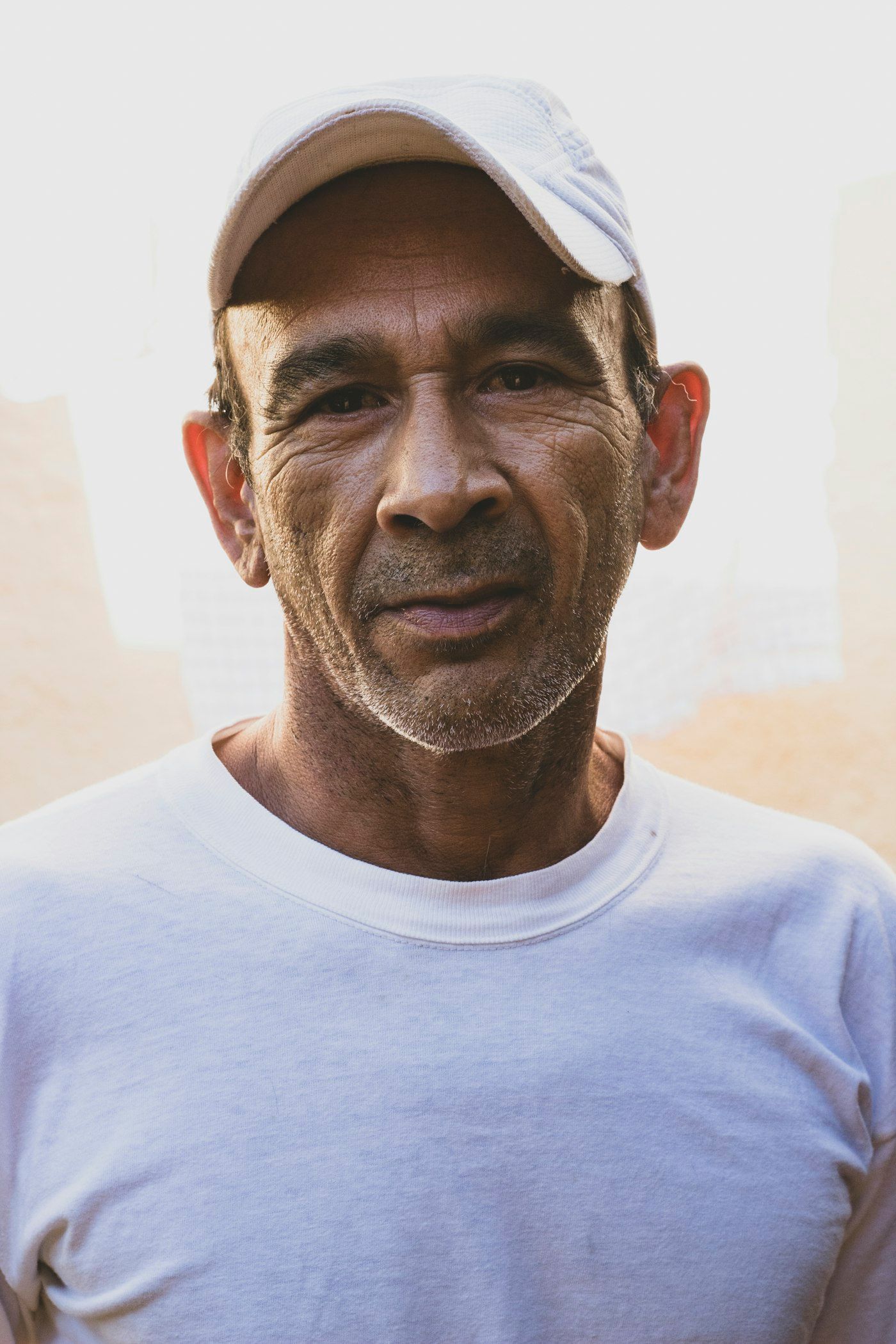 Portrait of a man in a white cap and light blue t-shirt in natural outdoor light
